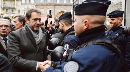 French Interior Minister Christophe Castaner (L) greets officers during the reopening of the christmas market of Strasbourg, eastern France, on December 14, 2018 as the author of the attack was killed on December 13, 2018. - The Chrismas market closed as three people were killed and 13 wounded when a lone gunman, identified as Cherif Chekatt, 29, opened fire on shoppers on December 11, 2018. (Photo by SEBASTIEN BOZON / AFP)
